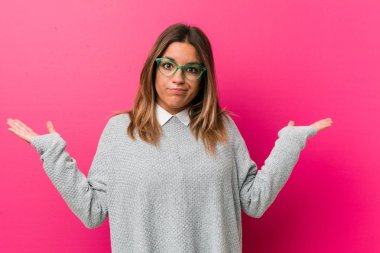 Genç otantik karizmatik gerçek insanlar kadın bir duvara karşı şüphe ve sorgulama jest omuzsat.