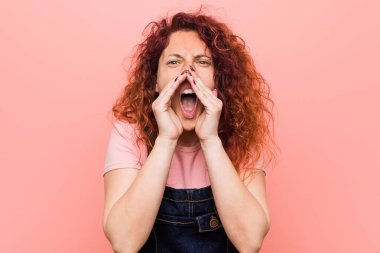 Genç güzel kızıl kızıl saçlı kadın ön heyecanlı bağırıyor bir kot dungaree giyiyor.