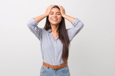 Genç güzel arap kadın sevinçle baş elleri tutarak gülüyor. Mutluluk kavramı.