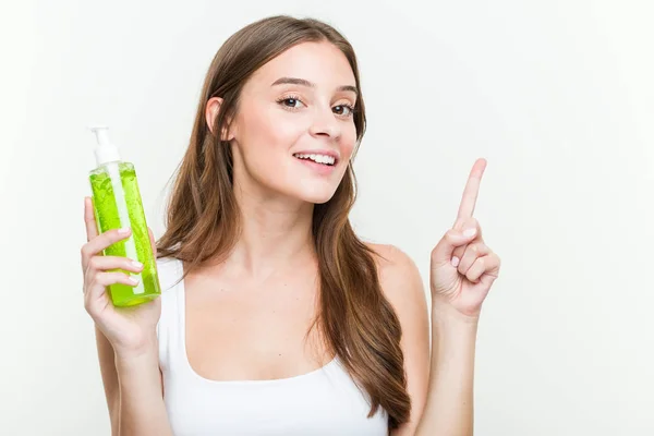 Young Caucasian Woman Holding Aloe Vera Bottle Smiling Cheerfully Pointing — Stock Photo, Image