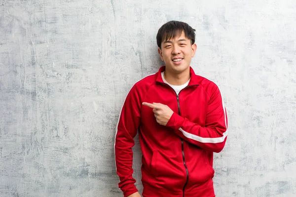 Joven Deporte Fitness Chino Sonriendo Señalando Lado —  Fotos de Stock