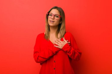 Bir duvara karşı genç otantik karizmatik gerçek insanlar kadın samimi bir ifade vardır, göğüs avuç içi basarak. Aşk kavramı.