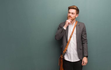 Genç kızıl saçlı iş adamı şüphe ve karışık