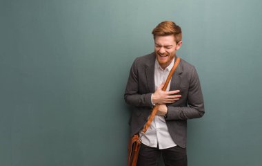 Genç kızıl saçlı iş adamı gülüyor ve eğleniyor