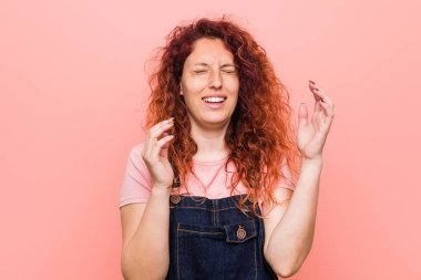 Genç güzel kızıl kızıl saçlı kadın bir kot dungaree neşeli çok gülüyor giyiyor. Mutluluk kavramı.