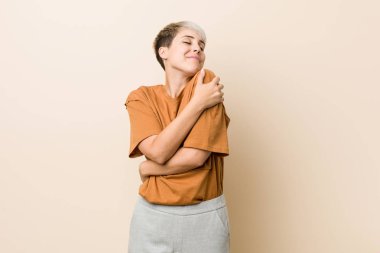 Kısa saç kucaklama ile genç artı boyutu kadın, kaygısız ve mutlu gülümseyen.