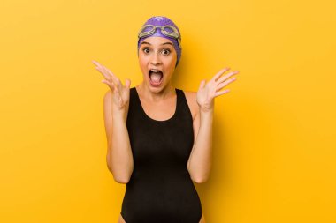 Genç yüzücü beyaz bir kadın bir zafer ya da başarı kutluyor, o şaşırır ve şok.