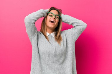 Bir duvara karşı Genç otantik karizmatik gerçek insanlar kadın sevinçle baş ellerini tutarak gülüyor. Mutluluk kavramı.