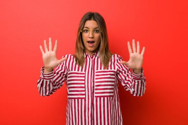 Genç otantik karizmatik gerçek insanlar kadın elleri ile on numara gösteren bir duvara karşı.