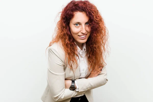 Young natural redhead business woman isolated against white background laughing and having fun.