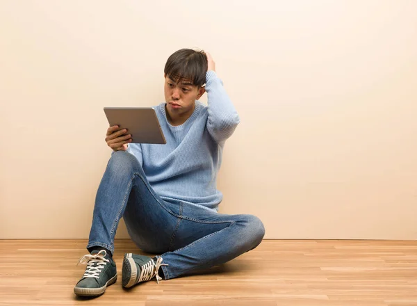 Young Chinese Man Sitting Using His Tablet Worried Overwhelmed — Stock Photo, Image