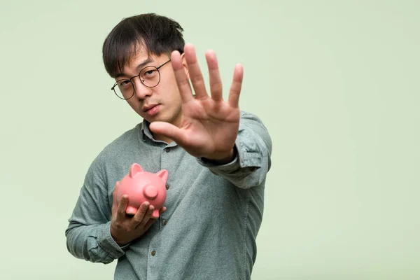 Jovem Asiático Homem Segurando Porquinho Banco Colocando Mão Frente — Fotografia de Stock