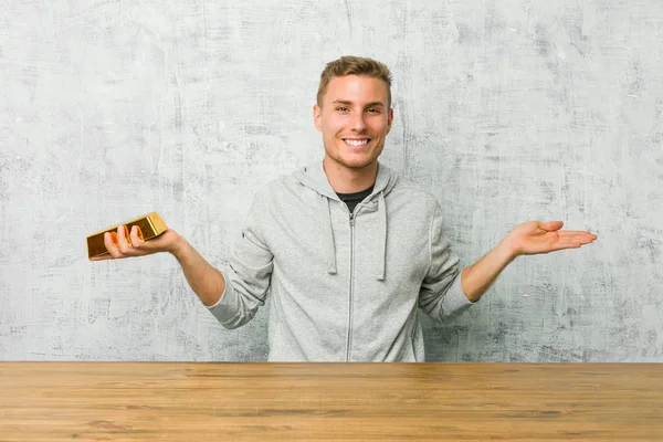 Jovem Homem Bonito Segurando Lingote Ouro Uma Mesa Faz Escala — Fotografia de Stock