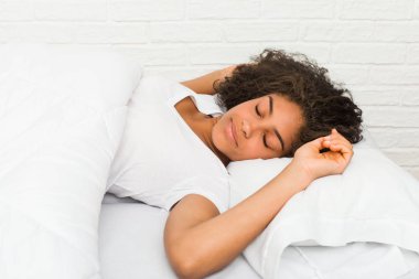 Yatakta uyuyan afrikalı-amerikalı yorgun bir kadının yakın çekim