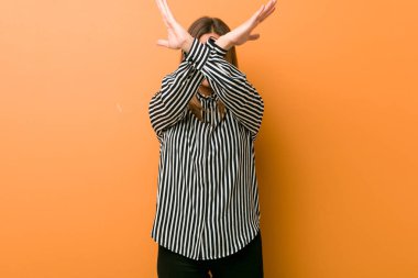 Genç otantik karizmatik gerçek insanlar kadın bir duvara karşı iki kol çapraz tutarak, inkar kavramı.