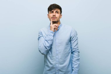 Genç İspanyol iş adamı şüpheli ve şüpheci ifade ile yan bakıyor.