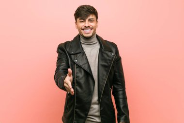 Tebrik jesti kamera da el germe deri ceket giyen genç İspanyol adam.