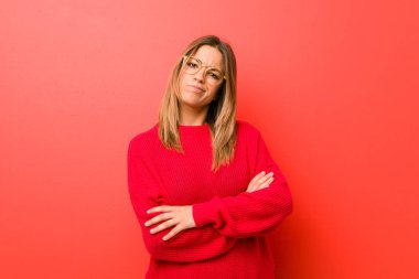 Genç otantik karizmatik gerçek insanlar kadın alaycı ifade ile kamera görünümlü mutsuz bir duvara karşı.