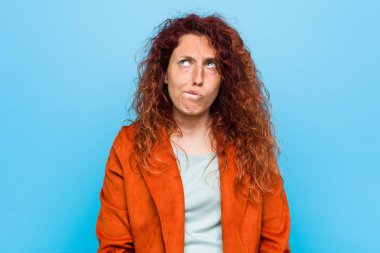 Genç kızıl saçlı zarif kadın karışık, şüpheli ve emin hissediyor.