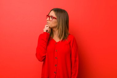 Şüpheli ve şüpheci ifade ile yana bakan bir duvara karşı Genç otantik karizmatik gerçek insanlar kadın.