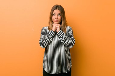 Bir duvara karşı Genç otantik karizmatik gerçek insanlar kadın çene altında ellerini tutar, bir kenara mutlu bakıyor.