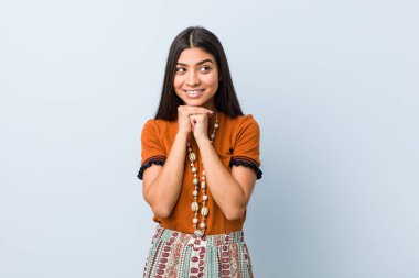 Young arab woman keeps hands under chin, is looking happily aside. clipart