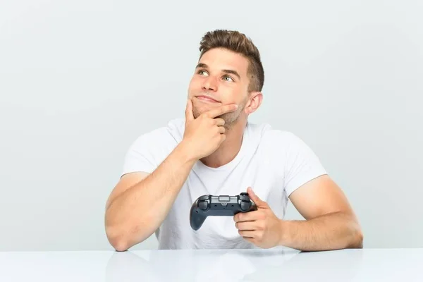 Junger Mann Mit Einem Spielcontroller Der Mit Zweifelndem Und Skeptischem — Stockfoto