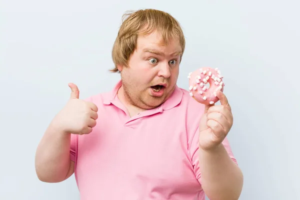 白种人疯狂的金发胖子拿着甜甜圈 — 图库照片