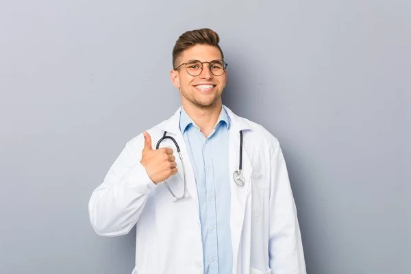 年轻的金发医生男子微笑 竖起大拇指 — 图库照片