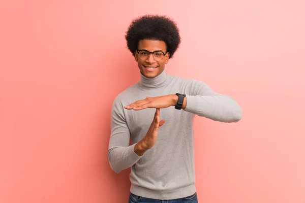 年轻的非洲裔美国人在粉红色的墙上做超时手势 — 图库照片