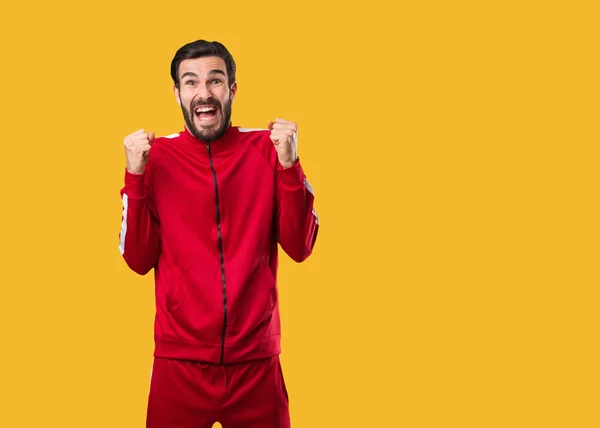 Young fitness man screaming very angry and aggressive