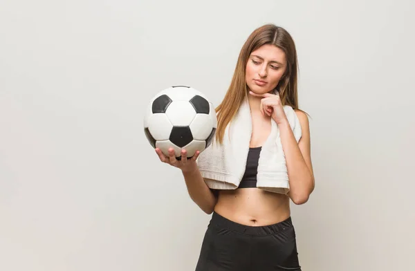 若いフィットネスロシアの女性は疑いと混乱 サッカーボールを持つ — ストック写真