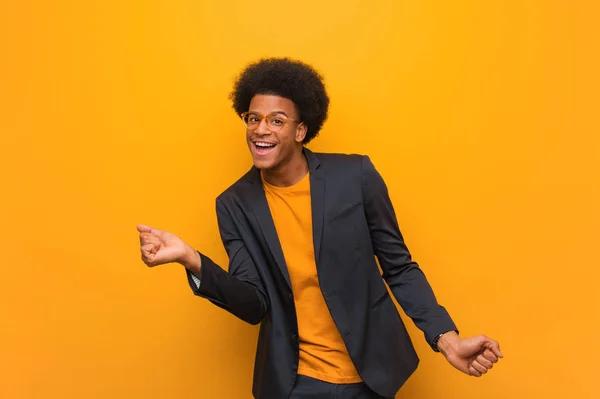 年轻的商业非洲裔美国人在橙色的墙壁跳舞和乐趣 — 图库照片