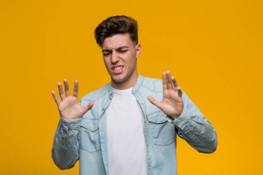 Kot gömlek giyen genç ve yakışıklı bir öğrenci iğrenme hareketi gösteren birini reddediyor..