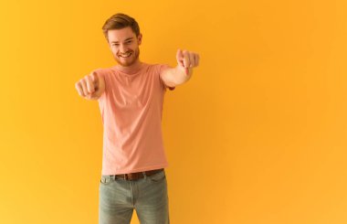 Young redhead man cheerful and smiling pointing to front
