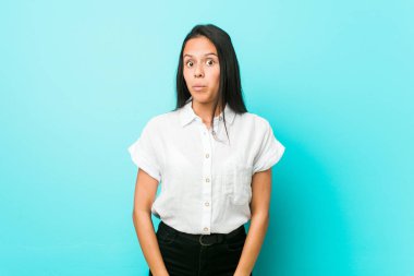 Genç, İspanyol asıllı, havalı bir kadın, mavi bir duvara yaslanmış omuzlarını silker ve gözleri açık kalır..