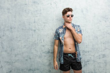 Mayo giyen genç beyaz bir adam virüs ya da enfeksiyon yüzünden boğazında ağrı hissediyor..