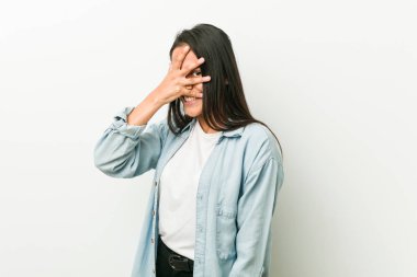 Genç İspanyol kadın kameraya parmaklarıyla göz kırpıyor, utanarak yüzünü kapatıyor..