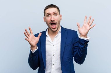 Genç beyaz adam zaferi ya da başarıyı kutluyor.