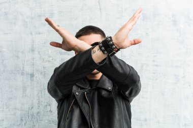 Genç rockçı iki kolu çapraz tutuyor, inkar kavramı.