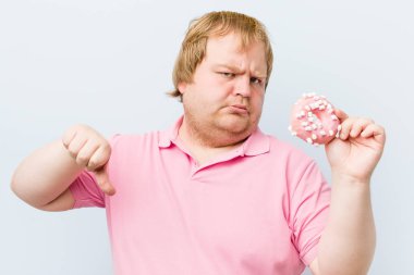 Beyaz çılgın sarışın şişman adam bir donut tutan