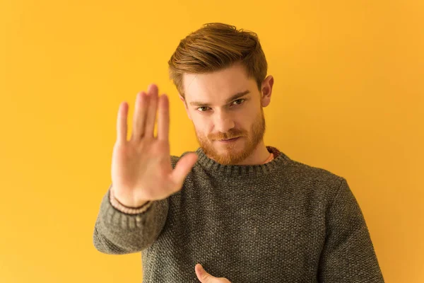 Young redhead man face closeup putting hand in front