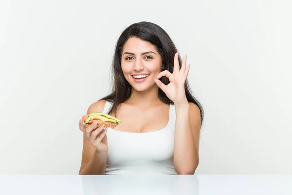 Young Hispanic Woman Holding Avocado Toast Cheerful Confident Showing Gesture — Stock Photo, Image