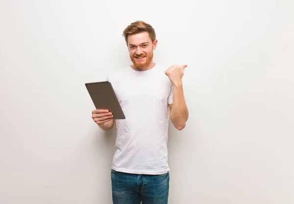 Mladý Rusovlasý Muž Ukazuje Prstem Stranu Držení Tablety — Stock fotografie