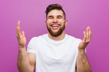 Genç, yakışıklı, beyaz bir adam çok gülüyor. Mutluluk kavramı.