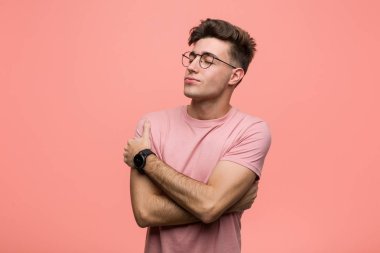 Kafkasyalı genç adam kendini kucaklıyor, kaygısız ve mutlu bir şekilde..