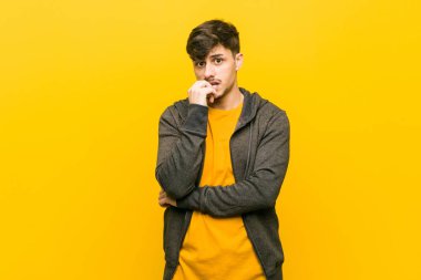 Young hispanic casual man relaxed thinking about something looking at a copy space.