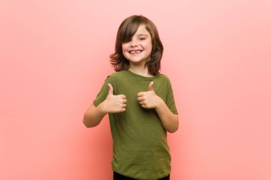 Little boy raising both thumbs up, smiling and confident. clipart