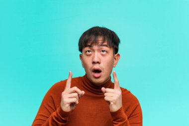 Genç Çinli bir adam bir şey göstermek için işaret etti.