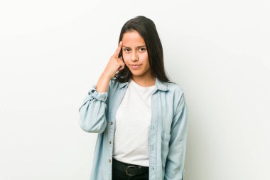 Genç İspanyol kadın parmak ile tapınak işaret, düşünme, bir görev üzerinde duruldu.